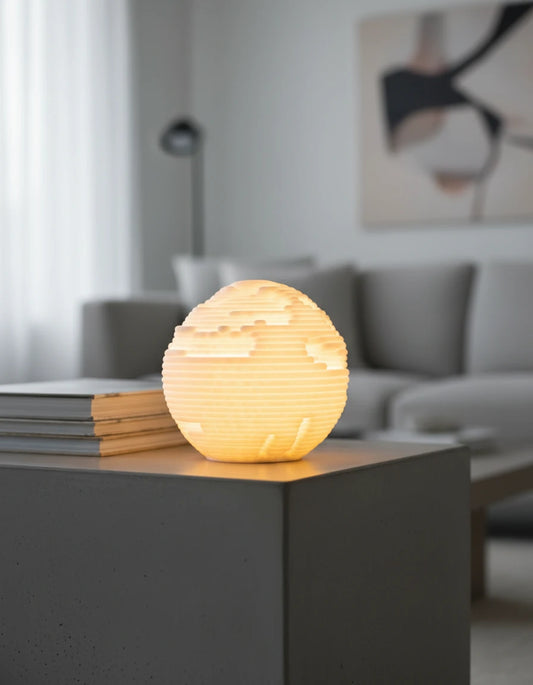 Lumira Orbis Mini rozsvietená v tmavej izbe na knihe